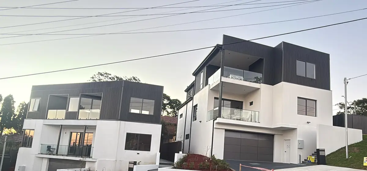 Two finished three-storey homes with dark cladding, Sydney