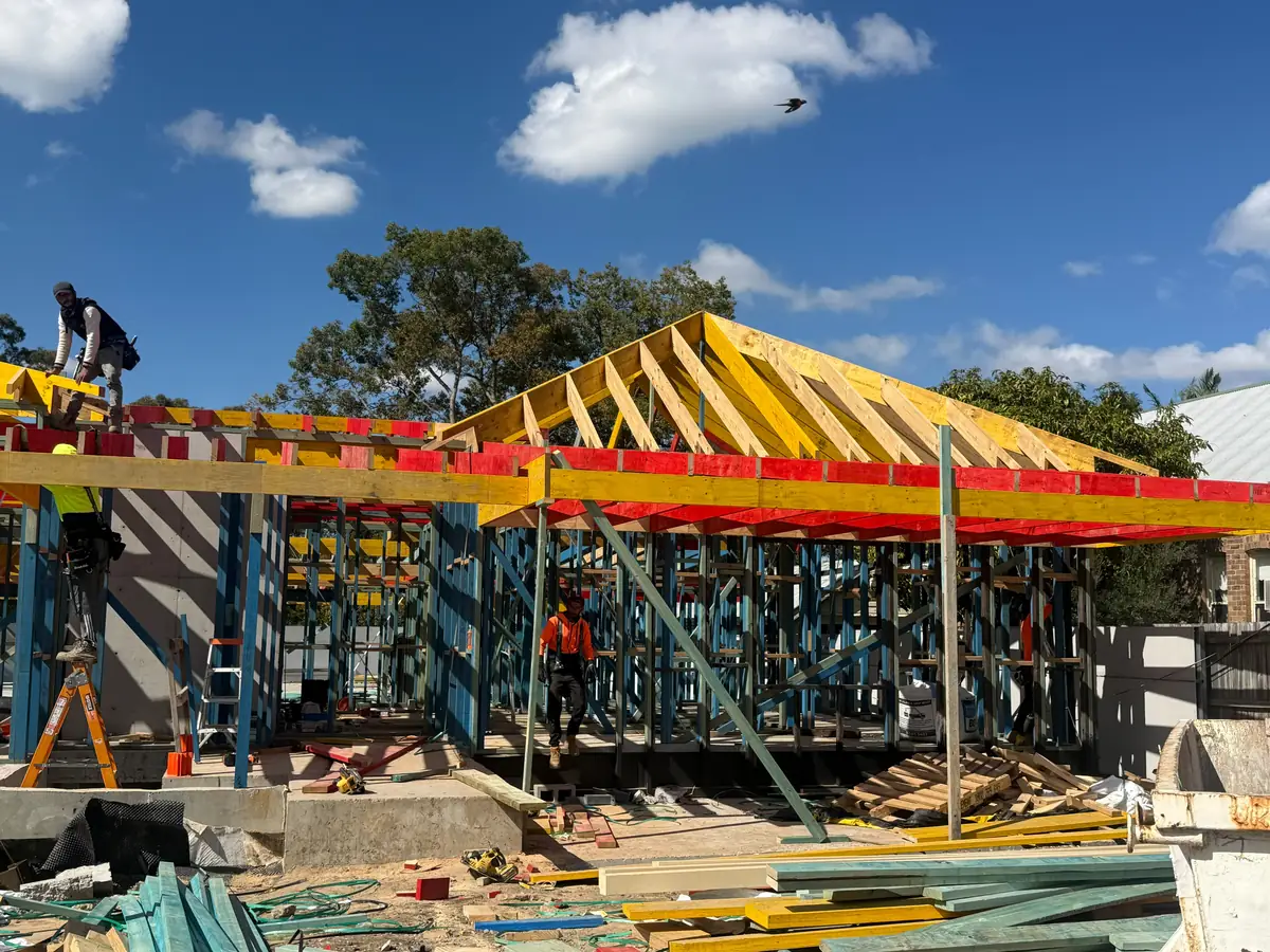 Roof trusses going up on a timber-framed home with the crew at work